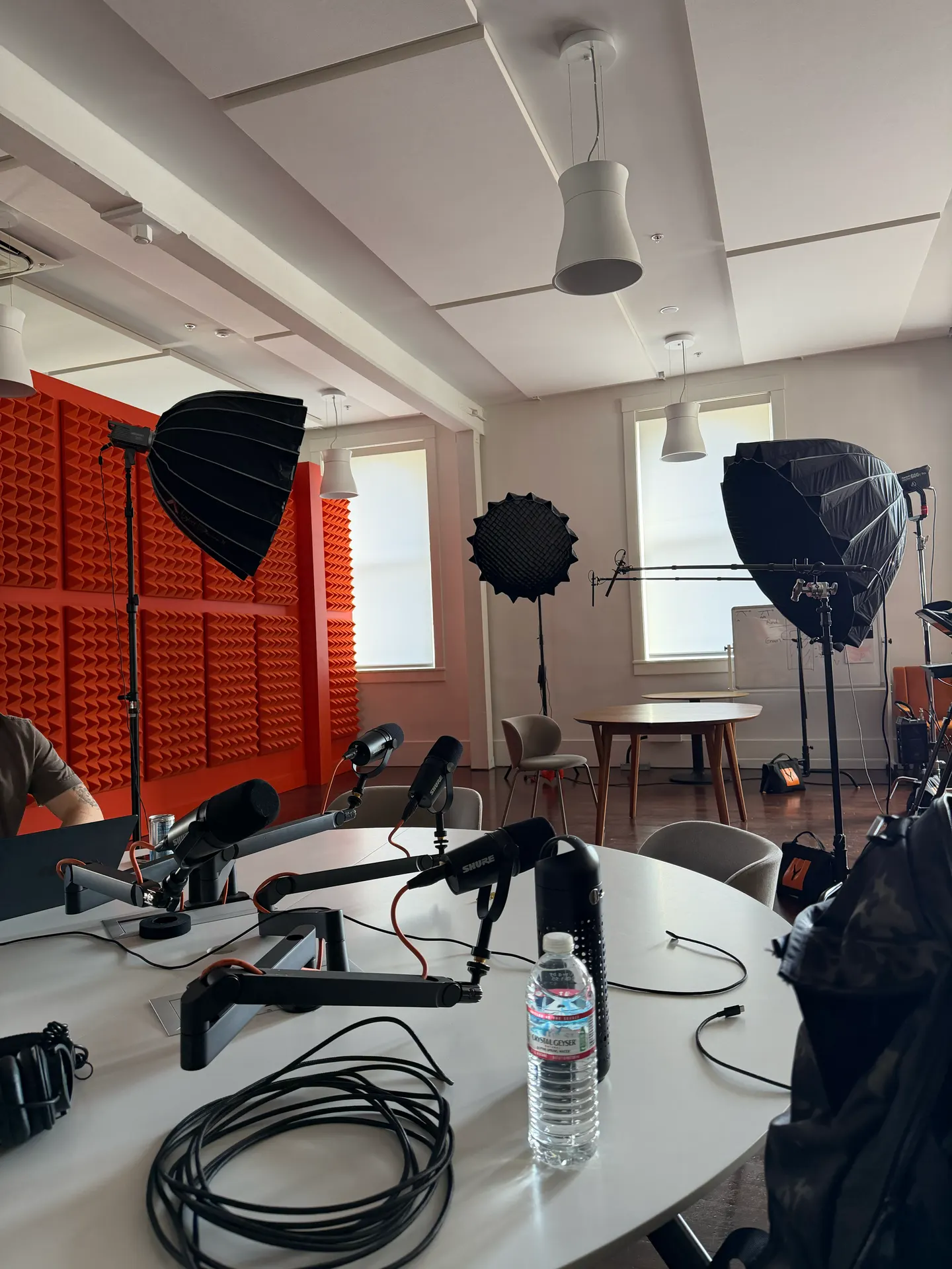 Microphones, studio lights, and orange acoustic panels in a recording studio